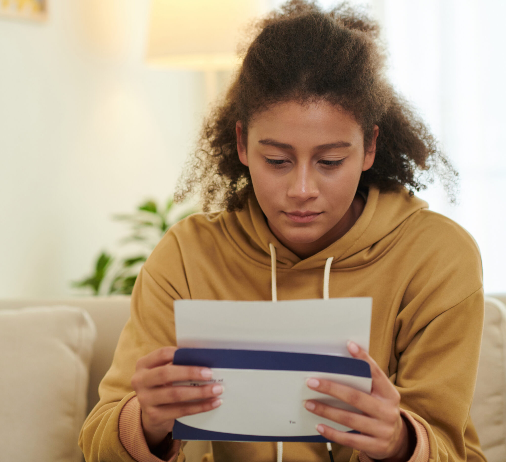 anxious-girl-opening-acceptance-letter-home-meic