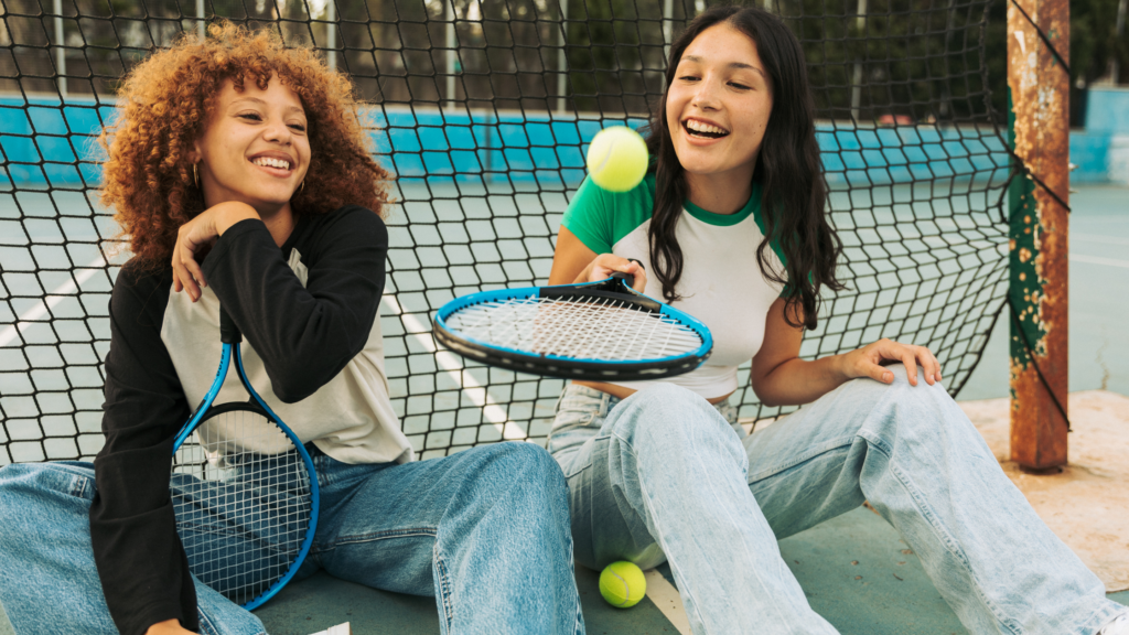 Teen girls sat on floor, playing with tennis rackets and balls
Wythnos Iechyd Meddwl