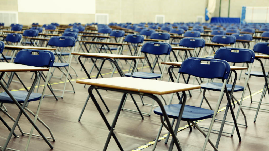Empty exam hall full of tables and chairs in a line