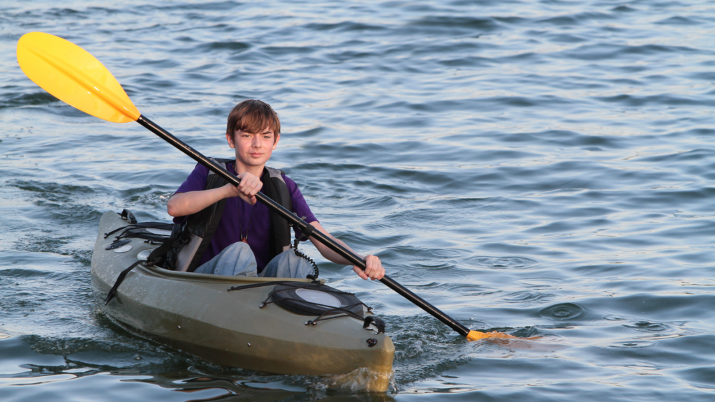 Teenage boy kayaking in the sea