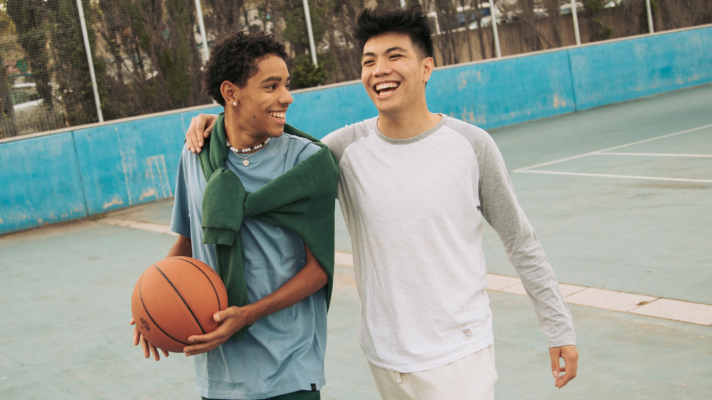 Two teen blogs walking together on a basketball court, with one holding a basketball
Wythnos Iechyd Meddwl